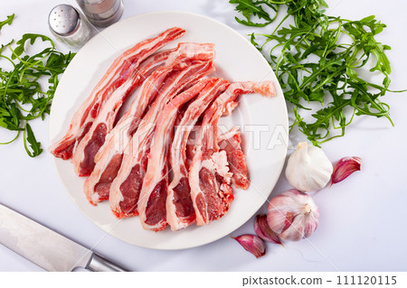Raw lamb chops on plate, over white background Raw lamb chops on plate, over white background 111120115