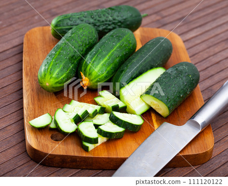 Ripe green cut cucumbers on wooden background 111120122
