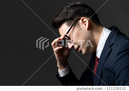 Businessman sitting on a chair and worrying 111120132