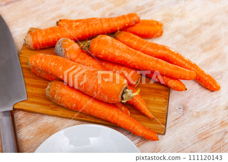 Raw unpeeled carrots on wooden table 111120143