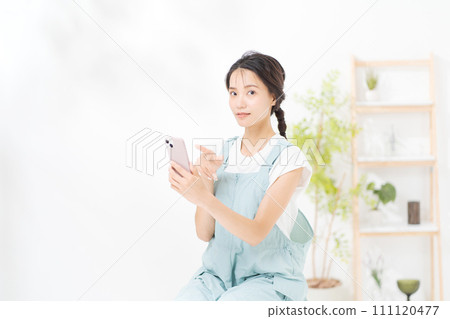 在她二十多歲的女人看著智能手機 在她二十多歲的女人看著智能手機 111120477