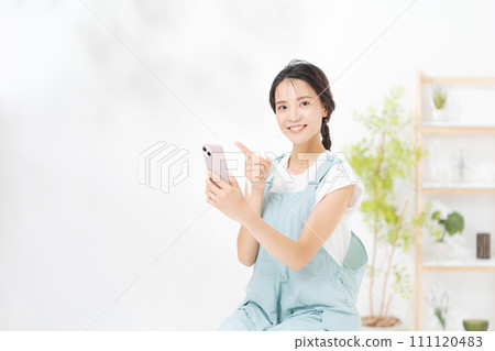 在她二十多歲的女人看著智能手機 在她二十多歲的女人看著智能手機 111120483