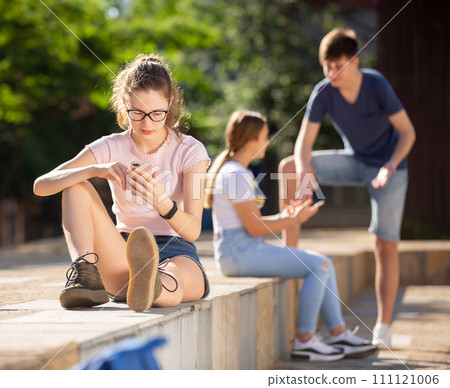 Teenage girl absorbed in social networks on phone 111121006