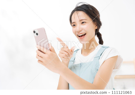 Woman in her twenties looking at a smartphone Woman in her twenties looking at a smartphone 111121063