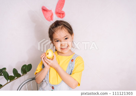Little girl paints and glues stickers on eggs 111121303