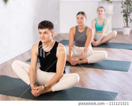 Group of young people sitting in a lotus pose. Group of young people sitting in a lotus pose. 111121321