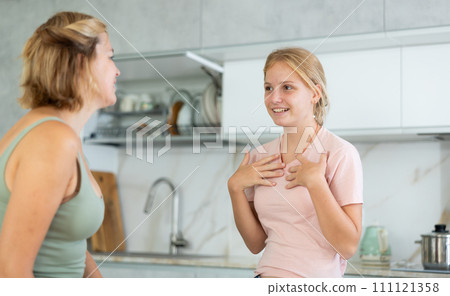 Teenage daughter enthusiastically tells unrecognizable mother about planned vacation with friends Teenage daughter enthusiastically tells unrecognizable mother about planned vacation with friends 111121358