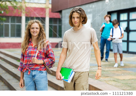 Boy and girl walking home after finishing lessons Boy and girl walking home after finishing lessons 111121380