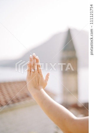 Girl examines the engagement ring on her outstretched hand. Cropped. Faceless 111121754