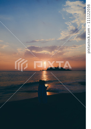 Silhouette of a young woman watching the sunset over a sea of clouds Silhouette of a young woman watching the sunset over a sea of clouds 111122036