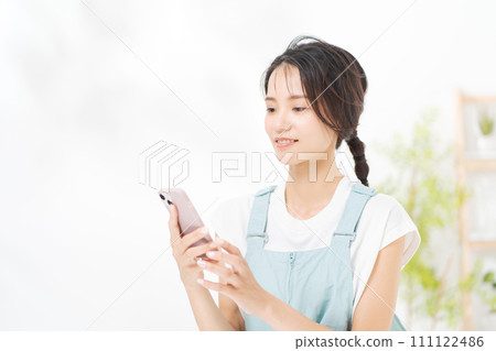 在她二十多歲的女人看著智能手機 在她二十多歲的女人看著智能手機 111122486