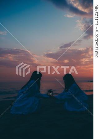 Silhouette of a young woman watching the sunset over a sea of clouds Silhouette of a young woman watching the sunset over a sea of clouds 111122496