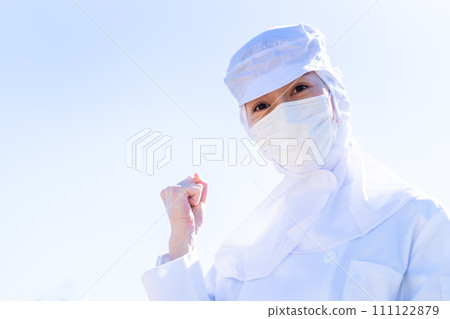 A young woman pumping her fists working at a food factory 111122879