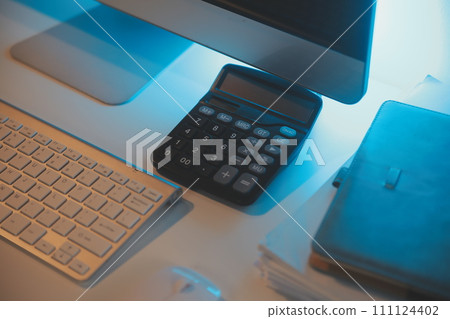Laptop and paperwork on conference table 111124402