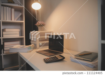 Laptop and paperwork on conference table 111124405