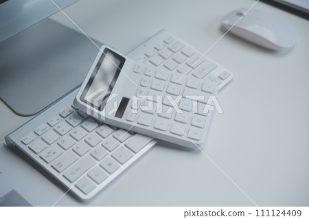 Laptop and paperwork on conference table 111124409