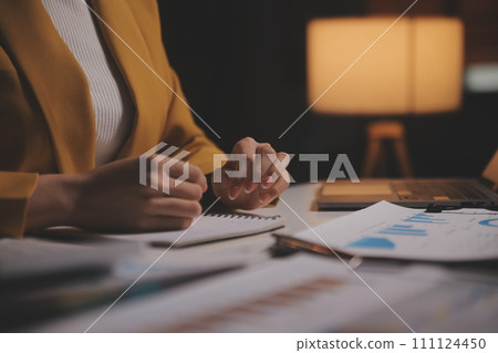 Business woman using calculator for do math finance on wooden desk in office and business working background, tax, accounting, statistics and analytic research concept Business woman using calculator for do math finance on wooden desk in office and business working background, tax, accounting, statistics and analytic research concept 111124450
