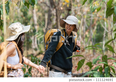 Happy LGBT Lesbian couple Travelers Hiking with Backpacks in forest Trail. LGBT Lesbian Couple Hikers with backpacks walks in mountains in vacation Happy LGBT Lesbian couple Travelers Hiking with Backpacks in forest Trail. LGBT Lesbian Couple Hikers with backpacks walks in mountains in vacation 111124691