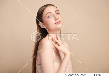 Beautiful young woman with clean fresh skin on beige background, Face care, Facial treatment, Cosmetology, beauty and spa, women portrait. 111126109
