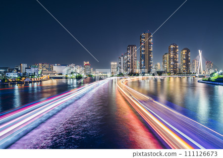 Urban night view of the Sumida River, light trails of boats extending towards Tsukuda Island [Chuo Ward, Tokyo] 111126673