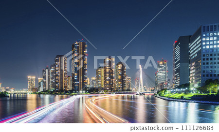 Urban night view of the Sumida River, light trails of boats extending towards Tsukuda Island [Chuo Ward, Tokyo] 111126683