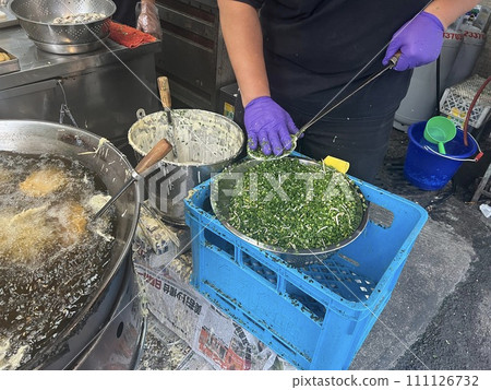 Photographing a vendor selling traditional delicacies frying oysters Photographing a vendor selling traditional delicacies frying oysters 111126732