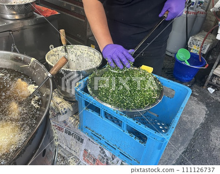 Photographing a vendor selling traditional delicacies frying oysters 111126737