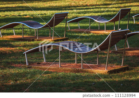 Empty sun loungers in park at sea Empty sun loungers in park at sea 111128994