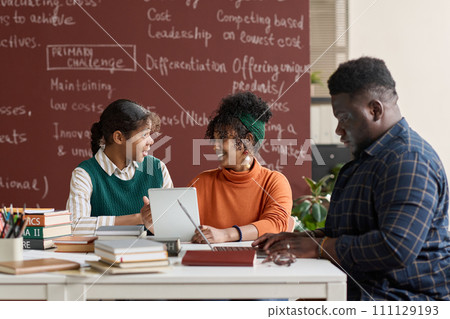 Group of young African American people discussing school project in classroom setting Group of young African American people discussing school project in classroom setting 111129193