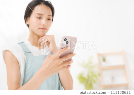在她二十多歲的女人看著智能手機 111130621