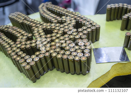 Emblem, coat of arms of Ukraine trident from used cartridges. Object made up of spent used cartridge cases. Lots used shells from cartridge cases ammo close up. Model from Many Used cartridge Cases. Emblem, coat of arms of Ukraine trident from used cartridges. Object made up of spent used cartridge cases. Lots used shells from cartridge cases ammo close up. Model from Many Used cartridge Cases. 111132107