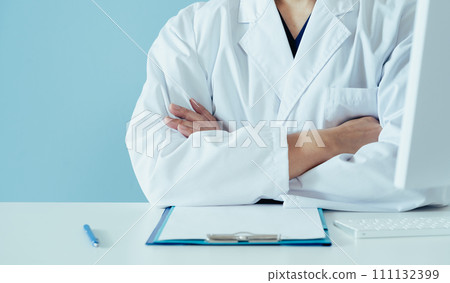 Middle-aged male doctor wearing a white coat Middle-aged male doctor wearing a white coat 111132399