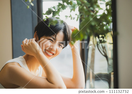 A woman watching the sunset by the window 111132732