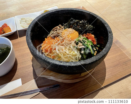 石烤石鍋拌飯(韓國菜)放在桌上的托盤上 石烤石鍋拌飯(韓國菜)放在桌上的托盤上 111133610