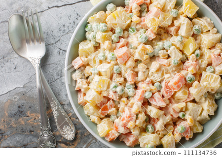 Vegetarian potato salad with green peas, carrots, corn and apple dressed with mayonnaise close-up on a plate. Horizontal top view Vegetarian potato salad with green peas, carrots, corn and apple dressed with mayonnaise close-up on a plate. Horizontal top view 111134736