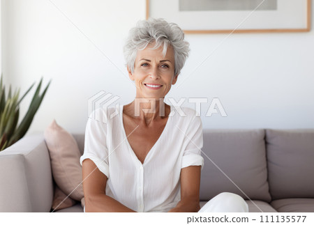 Portrait of smiling mature woman sitting on sofa i Portrait of smiling mature woman sitting on sofa i 111135577