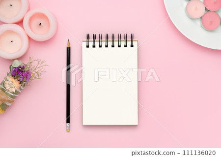 Blank spiral notebook notepad and pencil on pink background with smudge stick and pink candles. Flat lay design mockup with empty space. Holiday planning banner for a great year Blank spiral notebook notepad and pencil on pink background with smudge stick and pink candles. Flat lay design mockup with empty space. Holiday planning banner for a great year 111136020