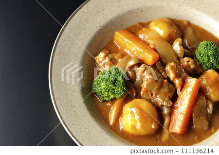 An overhead shot of beef stew with many ingredients such as broccoli, carrots, and shimeji mushrooms against a black background An overhead shot of beef stew with many ingredients such as broccoli, carrots, and shimeji mushrooms against a black background 111136214