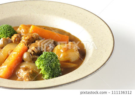 在白色背景下拍攝了包含西蘭花、胡蘿蔔和姬菇等多種食材的燉牛肉。 111136312