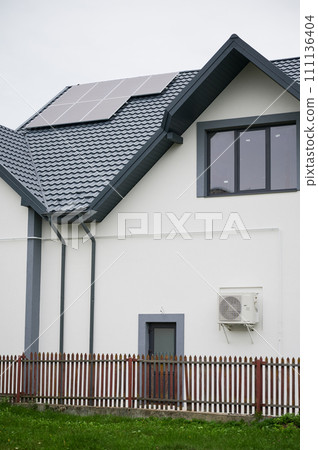 Bottom view of house with solar panels on roof. Photovoltaic solar system on modern house. Alternative energy resources in our life. Bottom view of house with solar panels on roof. Photovoltaic solar system on modern house. Alternative energy resources in our life. 111136404