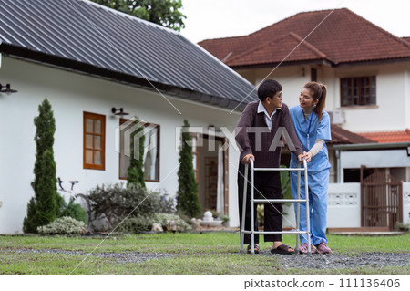 Nurse or caregiver helps elderly walk by using walker in garden Nurse or caregiver helps elderly walk by using walker in garden 111136406