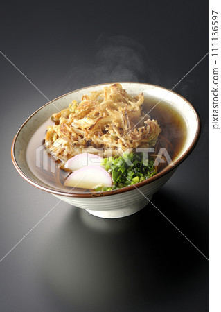 黑色背景下拍攝的熱 kakiage 蕎麥麵或天婦羅蕎麥麵,上面放著 kamaboko 和蔥 黑色背景下拍攝的熱 kakiage 蕎麥麵或天婦羅蕎麥麵,上面放著 kamaboko 和蔥 111136597