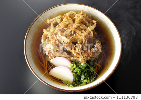 黑色背景下,熱騰騰的蕎麥麵或天婦羅蕎麥麵的頭頂照片,上面放著魚餅和洋蔥 黑色背景下,熱騰騰的蕎麥麵或天婦羅蕎麥麵的頭頂照片,上面放著魚餅和洋蔥 111136798