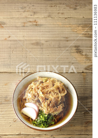 鳥瞰熱騰騰的炸蕎麥麵或天婦羅蕎麥麵,上面放著魚餅和洋蔥 鳥瞰熱騰騰的炸蕎麥麵或天婦羅蕎麥麵,上面放著魚餅和洋蔥 111136983