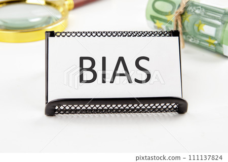Bias the text on the business card next to the roll of money with a magnifying glass in the background is out of focus on a white background 111137824