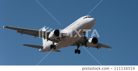The plane lands.Airplane, passengers flying in the blue sky, preparing to land at the airport The plane lands.Airplane, passengers flying in the blue sky, preparing to land at the airport 111138319