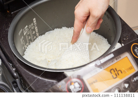 Mix the cooked rice with a rice paddle Mix the cooked rice with a rice paddle 111138811