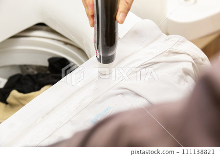 Apply stick detergent to the stain on the collar of a dirty shirt 111138821