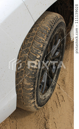 Car wheel on a sandy road with tire packed  with sand 111139028