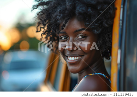 Smiling African American woman leaning on car window Smiling African American woman leaning on car window 111139433